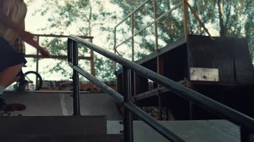 Active Teen Skater Jumping on Rail with Skate Board at Urban Skate Park