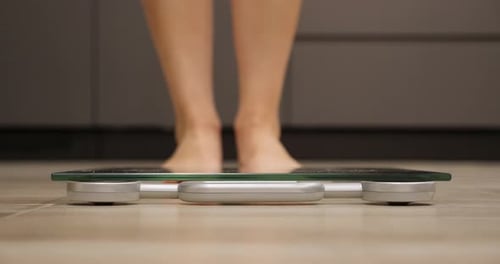 Bare Feet Stepping on Digital Bathroom Scale
