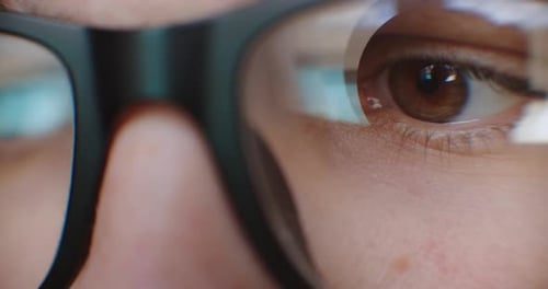 Eyes with Glasses Reflecting Digital Screen Close-up