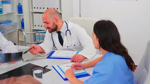 Doctors and Nurse Reviewing Patient X-Rays in Office
