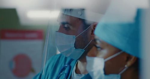 Serious Medical Professionals Wearing Masks in Hospital