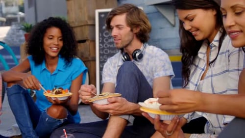 Smiling friends eating snacks