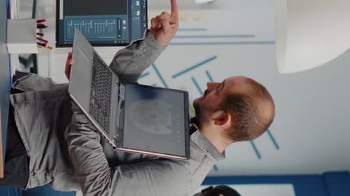 Supervisor de proyecto hombre sosteniendo portátil y apuntando en la pantalla