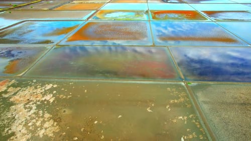 Aerial view flying over a beautiful colorful natural sea salt pond