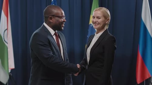 Business People Shaking Hands in front of Flags