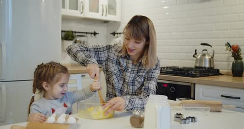 Mother and Daughter Baking Together in Kitchen