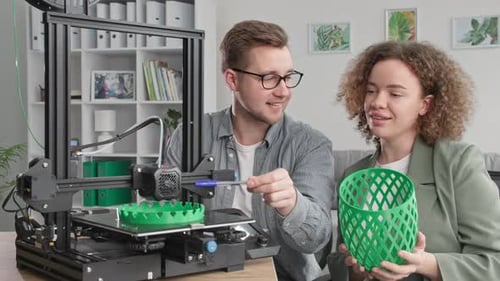 Progrès technologiques Un homme moderne et une fille souriante regardent joyeusement l'impression d'un prototype d'imprimante 3D à