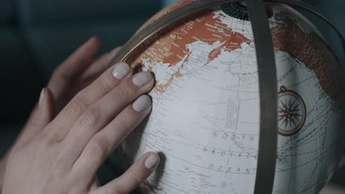 Woman's Hands Spinning Vintage Globe Close Up