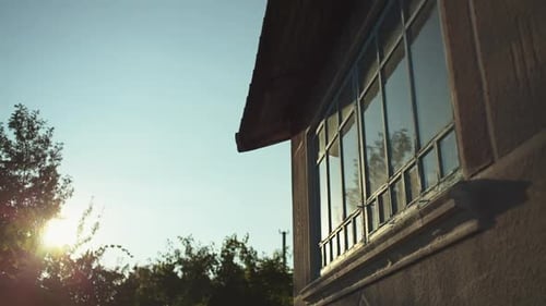 Spiegelung des Sonnenuntergangs, Morgendämmerung im Fenster in einer alten Hütte auf dem Land.