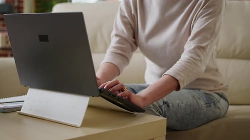 Woman Uses Laptop on Couch at Home
