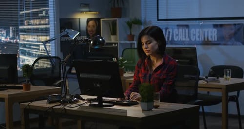 Jeune femme travaillant la nuit dans un bureau