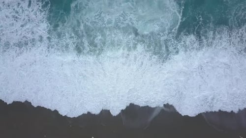Aerial Top View Turquoise Waves Break on Empty Beach, Ocean Waves Reaching Shore From Above