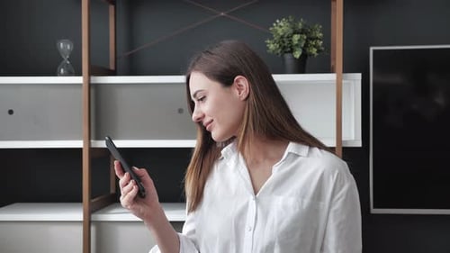 Smiling Woman Using Smartphone Indoors