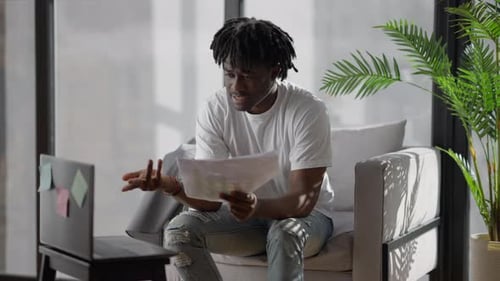 Portrait d'un jeune homme sérieux parlant lors d'un chat vidéo montrant des graphiques commerciaux à une caméra Web