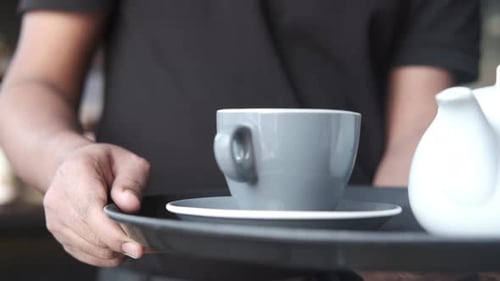 Kellner serviert Tee oder Kaffee im Café