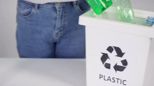 Putting Plastic Bottles in Recycling Container