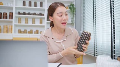 Woman Presenting Decorative Vase in Home Studio
