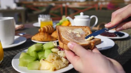 Butter Spreading on Toast at Breakfast Table