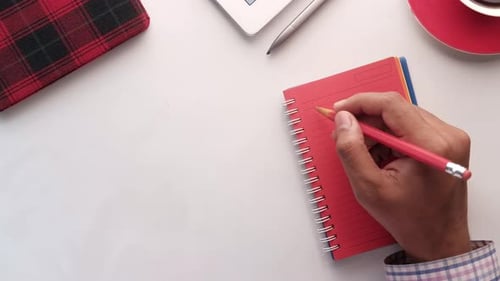Top View of Man Hand Writing on Notepad.