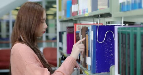 Asian beauty college student reading book in library.