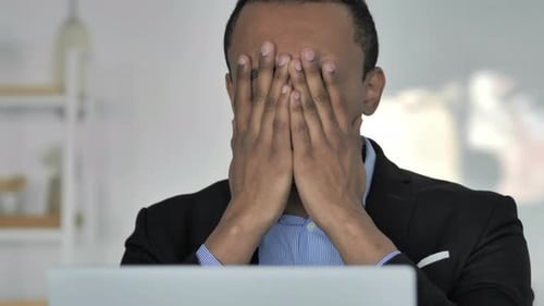 Gros plan d'un homme d'affaires afro-américain occasionnel en colère réagissant à une perte financière au travail