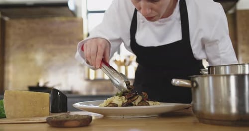 Chef Plates Pasta Dish in Restaurant Kitchen