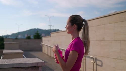 Woman Drinks Water in City After Workout