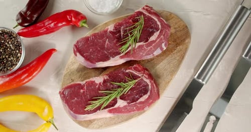 Raw Steaks with Rosemary and Peppers Overhead