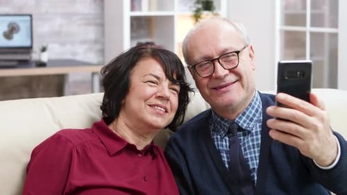 Smiling Couple Looks at Mobile Phone Together