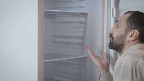 Man Looks Inside Clean Empty Refrigerator