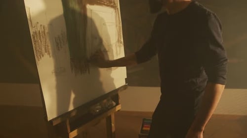 Bearded Man Creating Charcoal Art at Easel