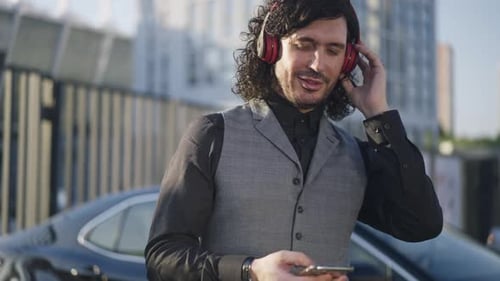 Man Listening to Music with Mobile Phone in City