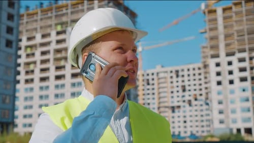Civil Engineer Talking on Phone Against Construction Site