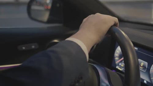 Hand on Steering Wheel in a Modern Car