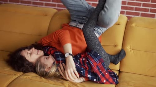 Mutter und kleines Kind im Vorschulalter genießen Bonding und springen auf die Couch