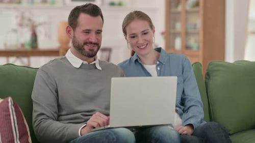 Couple Video Chatting Together on Laptop at Home