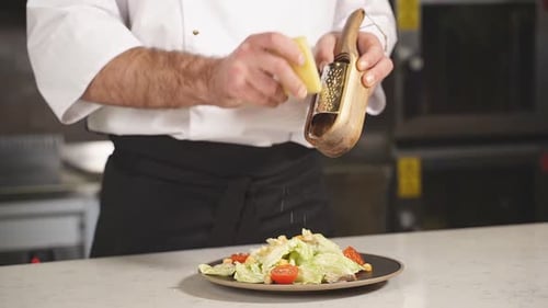 Chef Grating Cheese onto a Fresh Salad