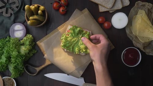 Flat Lay of Making the Sandwich with Sliced Bacon and Salad, Chef Adds Salad To the Sandwich on the