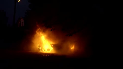 Car Burning in Flames at Night in Urban Area