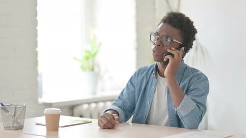 Young Adult Arguing on Phone in Office