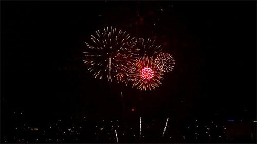 Fireworks Exploding Over City at Night