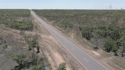 Plan lent d'une voiture prise par un Drone à quatre roues motrices sur une longue autoroute droite dans le Territoire du Nord, Austr