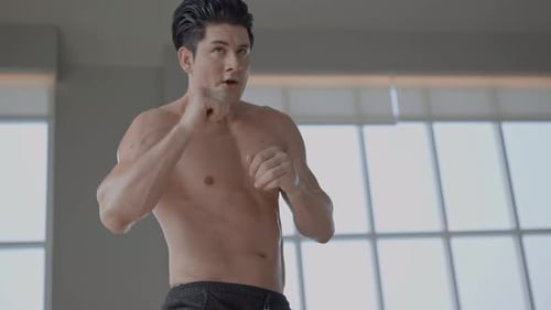 Shirtless Man Shadow Boxing in Bright Room