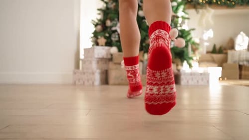Female Legs in Red New Year's Socks Run to Decorated Christmas Tree with Gifts