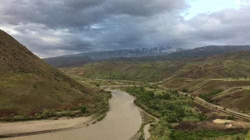 Scenic River Valley Landscape with Passing Train