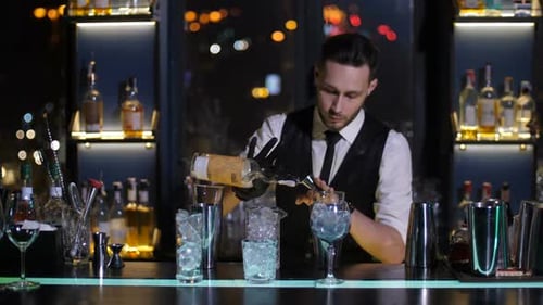 Barman Versant de l'alcool de la bouteille dans un doseur au bar
