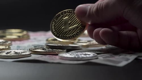 Montrant la pièce Litecoin au-dessus des autres pièces et des billets tchèques, gros plan.