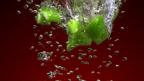Vibrant Green Celery Slices Falling Into Water
