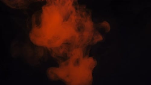 Red Ink Swirling on Black Background