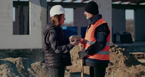 Concentrated Engineers Discussing Examining and Developing at Construction Site